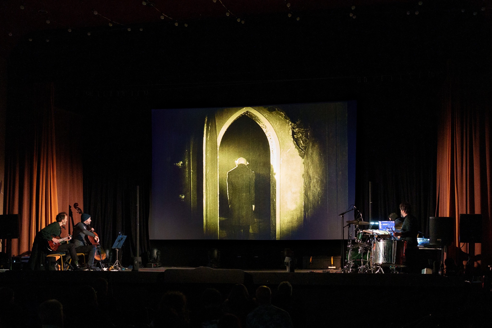 Photo of Minima performing as Nosferatu plays in the background