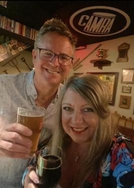 George and Louise holding up pints and smiling into the camera