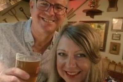 George and Louise holding up pints and smiling into the camera